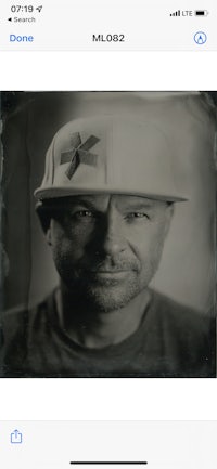 a photo of a man in a hat is displayed on an iphone